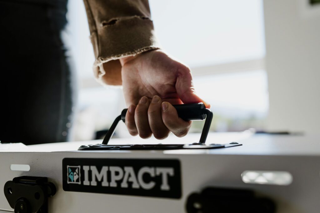 pexels photo 28333015 28333015 Close-up of a hand gripping an Impact dog crate handle indoors.