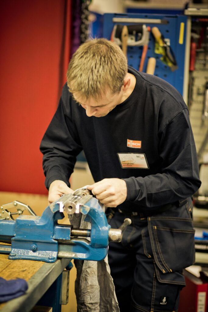pexels photo 325683 325683 A focused man crafting metal in a workshop with precision tools and equipment.